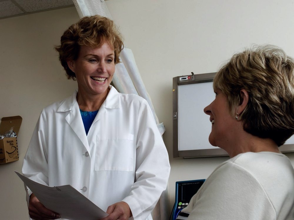 Experienced female physician talking with an older patient